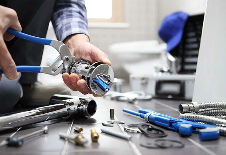 Technician repairing a plumbing fixture with professional tools in Marina