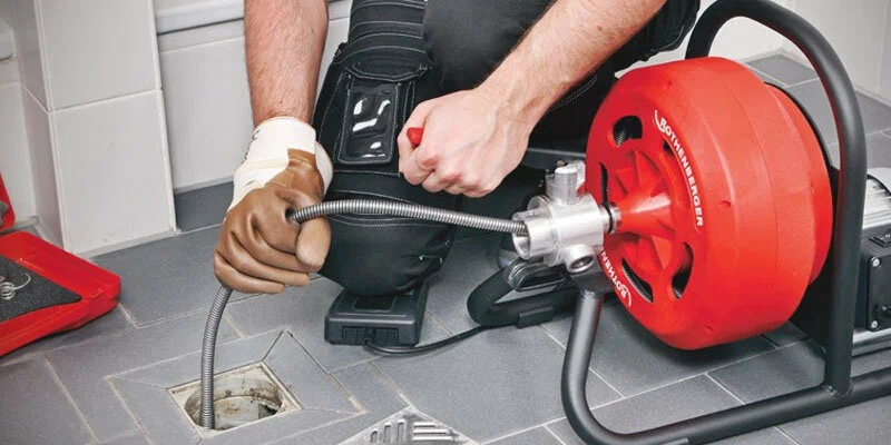 Plumber using a drain-cleaning machine in Marina