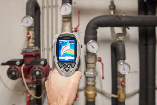 Plumber using a thermal imaging camera to inspect pipes in Marina