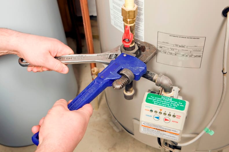 Plumber repairing a water heater valve in Marina